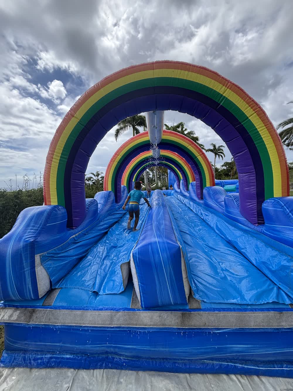 Toboggan gonflable géant arc-en-ciel installé pour un arbre de Noël d'entreprise à La Réunion